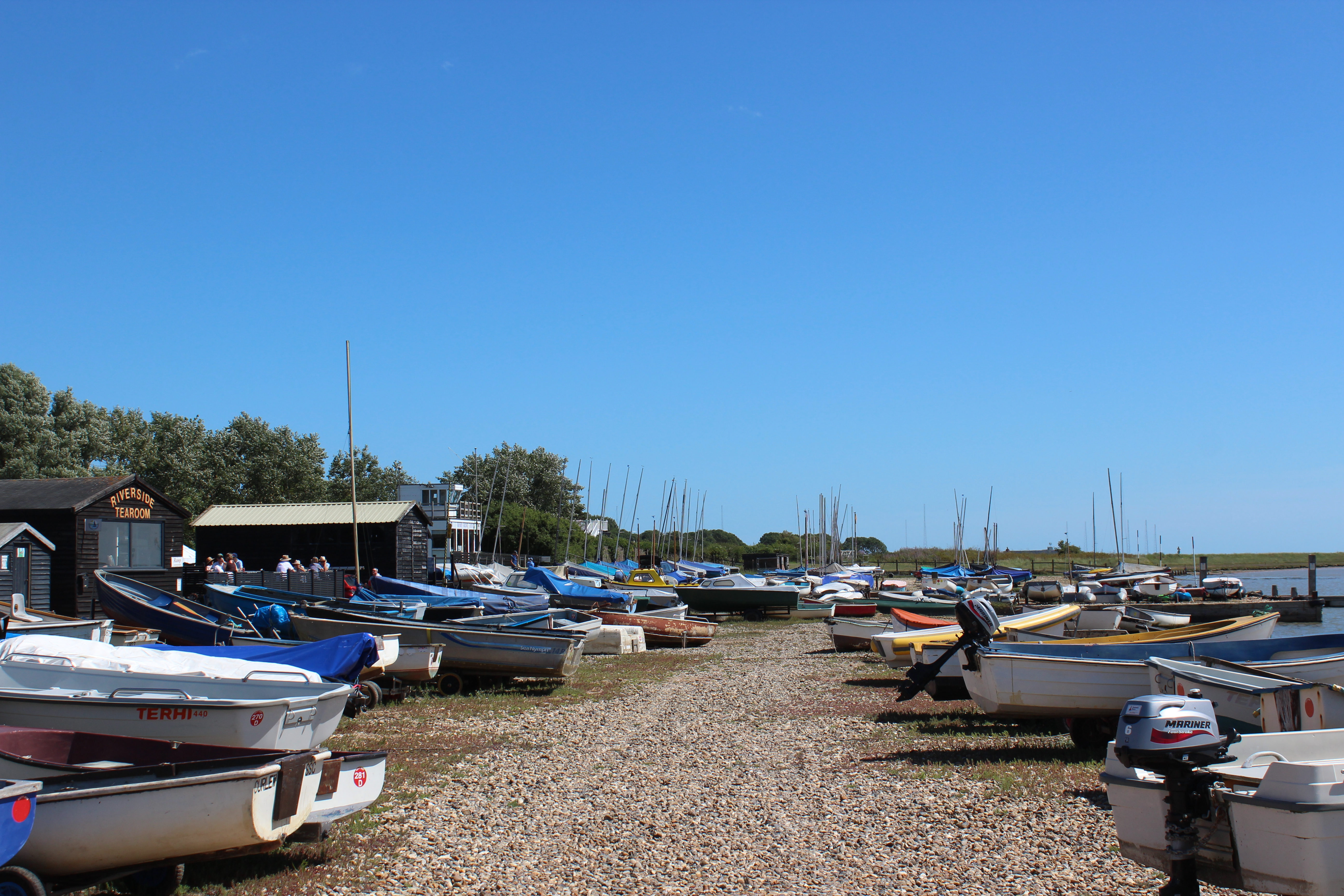 Boats on the shingle at Orford quay on a clear summer morning